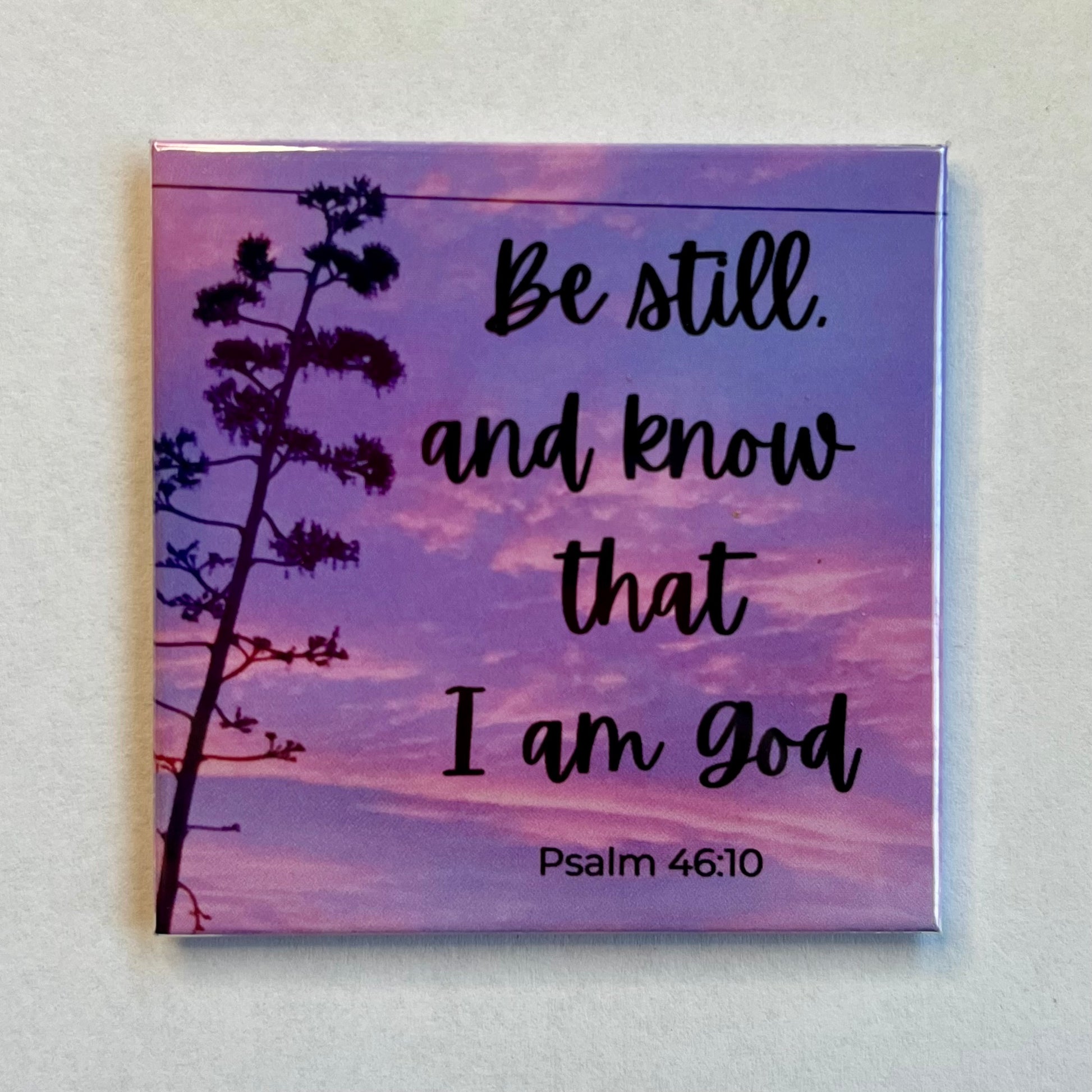 Bible verse magnet with purple and pink sunset reading Be Still and Know That I Am God Psalm 46:10