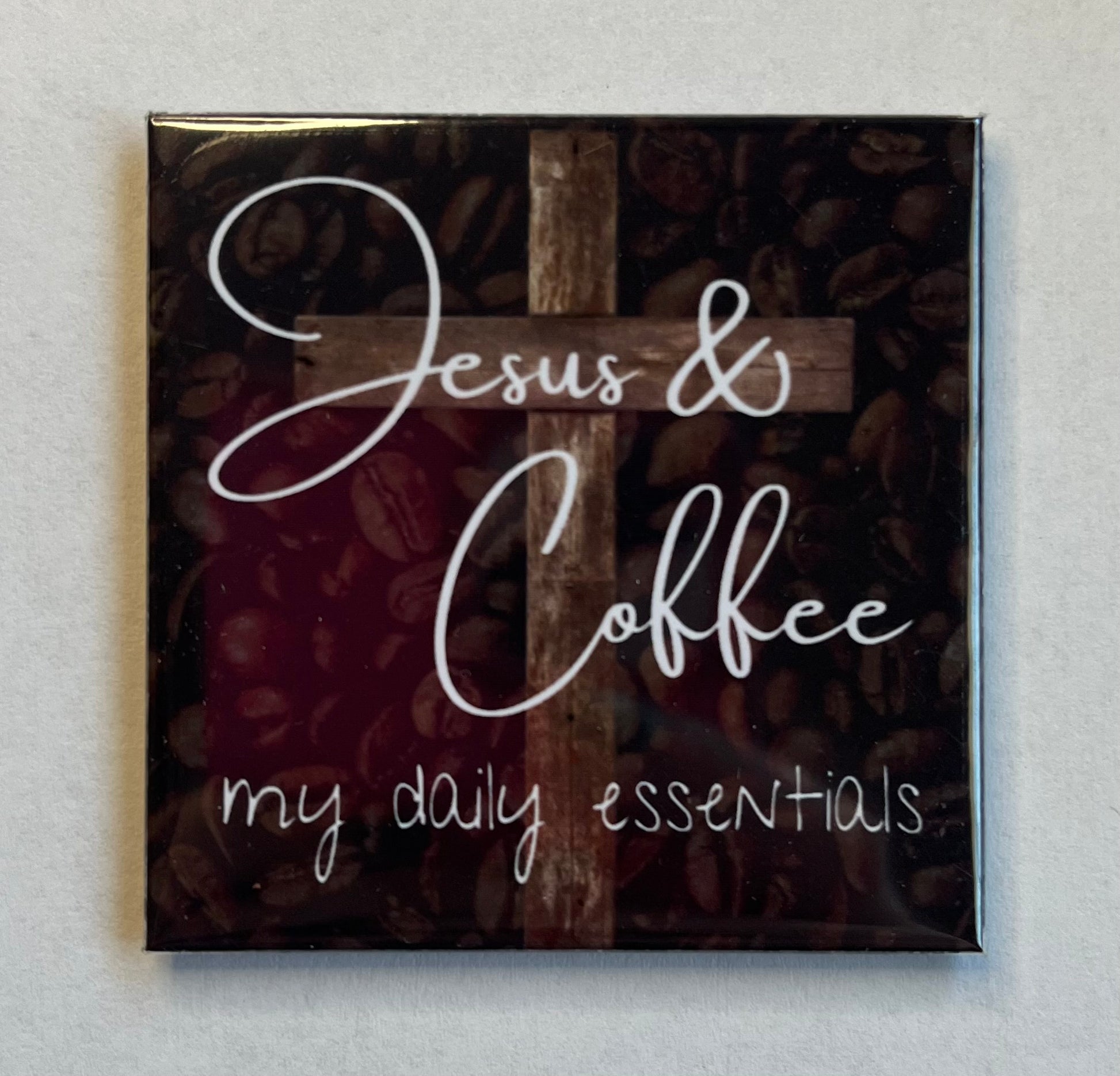 Christian coffee magnet with coffee beans background and wooden cross reading Jesus and Coffee My Daily Essentials