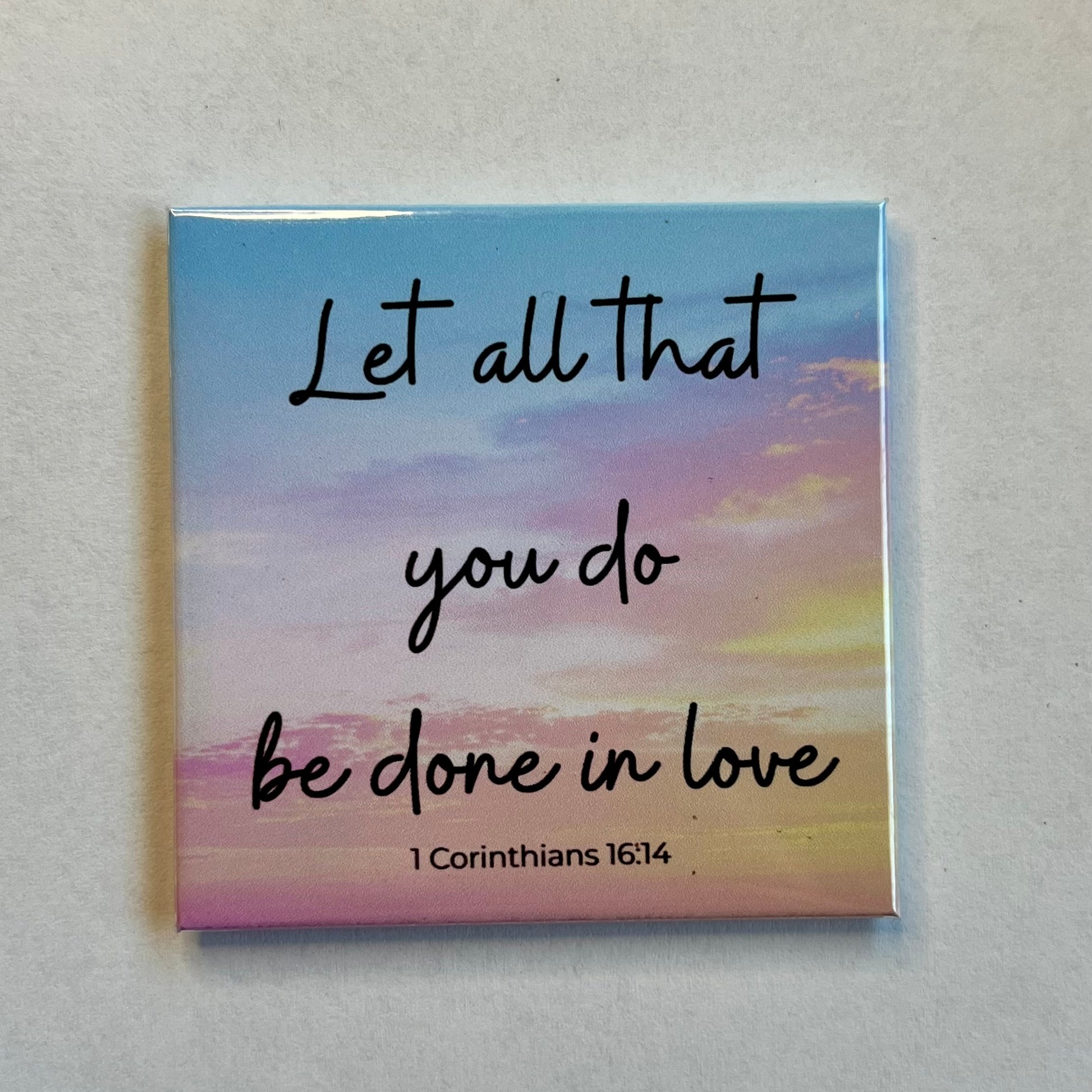 Christian scripture magnet with light sunset sky reading Let All That You Do Be Done in Love 1 Corinthians 16:14