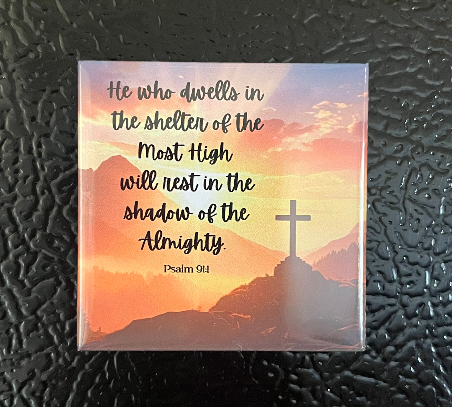Psalms Scripture magnet on a refrigerator with a cross on a mountain at sunset and Psalm 91:1
