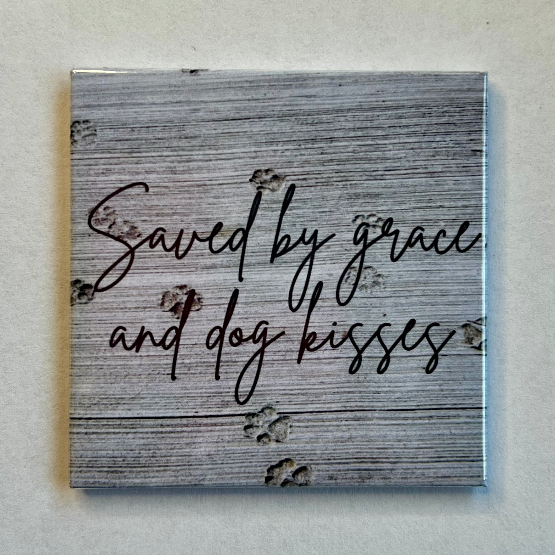 Faith-based dog magnet with cement background and paw prints reading Saved by Grace and Dog Kisses